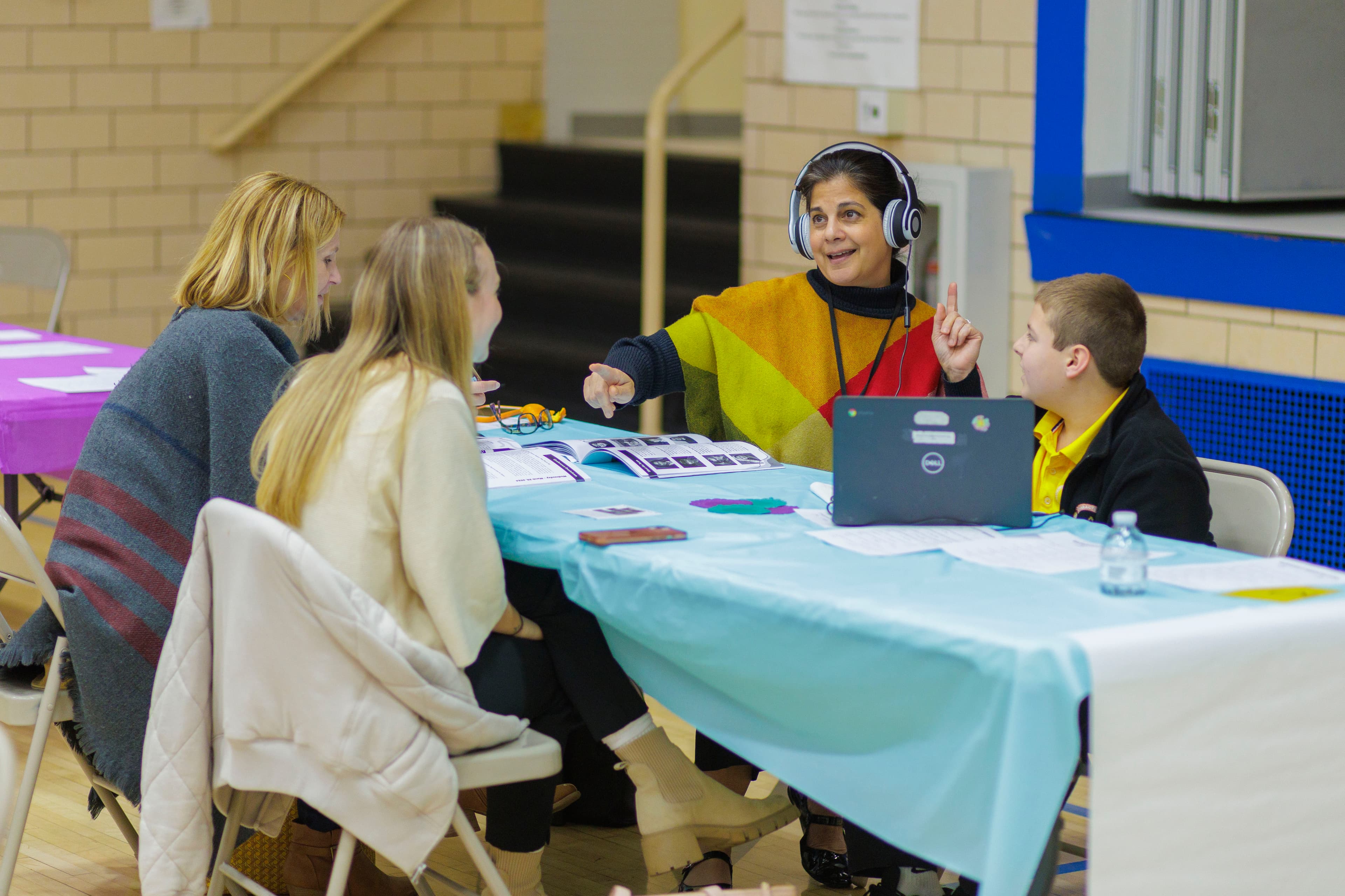An educator wearing headphones listens to a student composition during a Conduction session